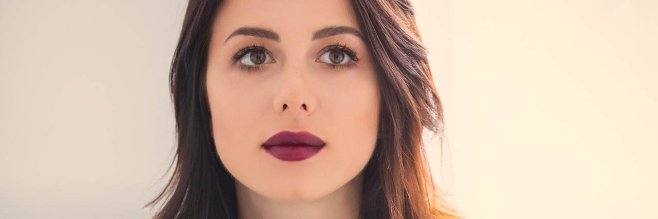 I No Longer Want to Hide My Illness A woman holding a cup of coffee, looking off to the distance.