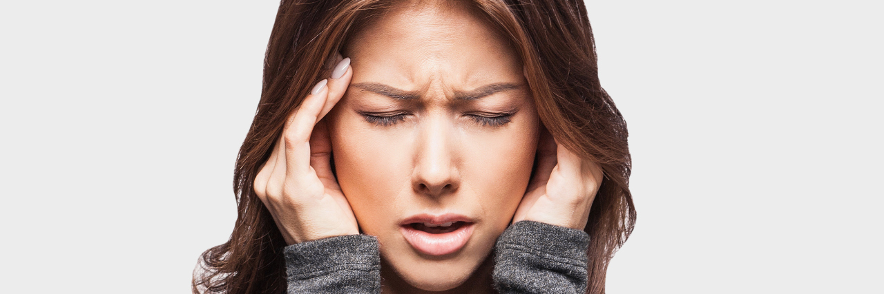 What You Can Do Instead of Apologizing Because I Get Migraines A woman touching her head, in pain.