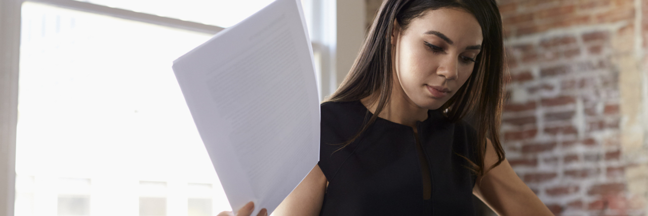 8 Ways I Hide My Mental Illness at Work Businesswoman Making Notes On Document In Office