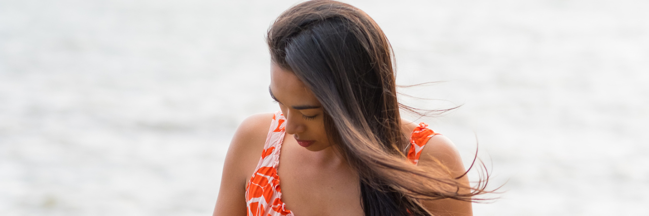 What I Want My Family and Friends to Know About Meniere's Disease A woman standing in front of the ocean.