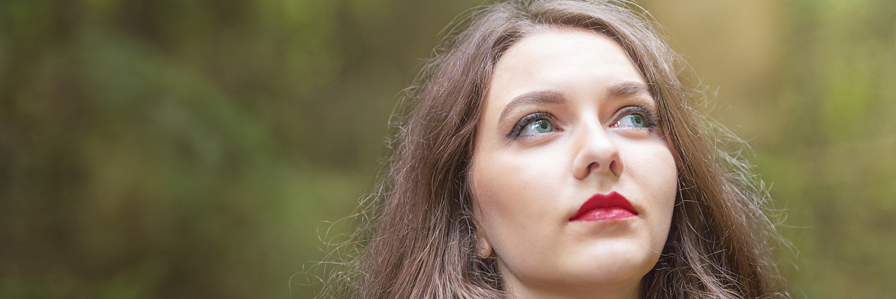 The Importance of Optimism When Trying New Chronic Pain Treatments A woman looking up at the sky with optimism.