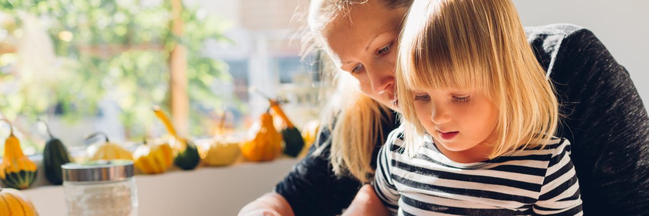 Navigating The Holidays With a Child Who Has Celiac Disease mother helping daughter make treats in the kitchen