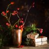 Christmas gift boxes among fir branches and rose hips on a rustic wooden table.