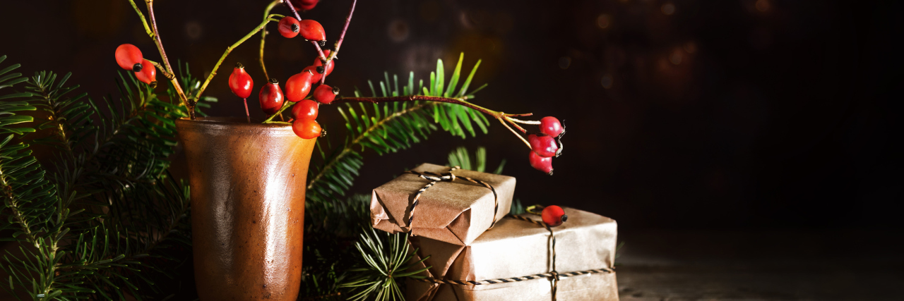 What Helps My Epilepsy During the Holidays Christmas gift boxes among fir branches and rose hips on a rustic wooden table.