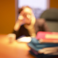 blurred image of woman sitting at her desk
