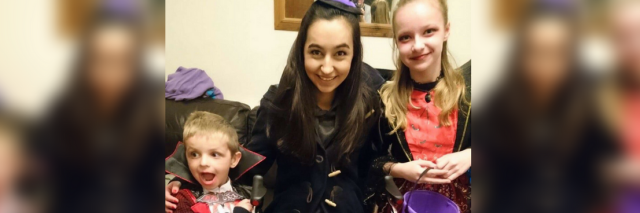 woman sitting on her rollator walker with her two younger siblings before going out trick or treating