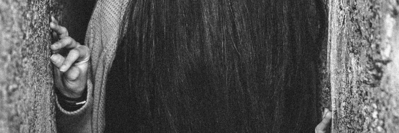 When Suicidal Thoughts Are Chronic woman with hair hiding face between two falls tight space