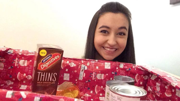 girl holding box of food to donate