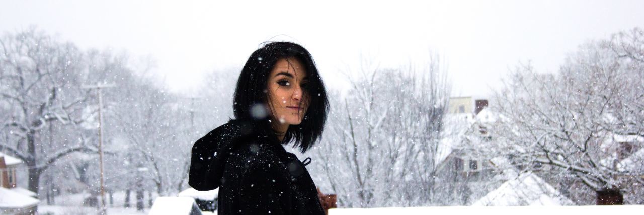 My Holiday Survival Guide for Teenagers Struggling With Mental Illness teenager with short black hair stands outside in the snow