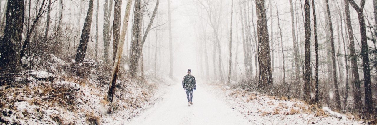 How to Help a Friend With Seasonal Depression man walking alone in snowy woods