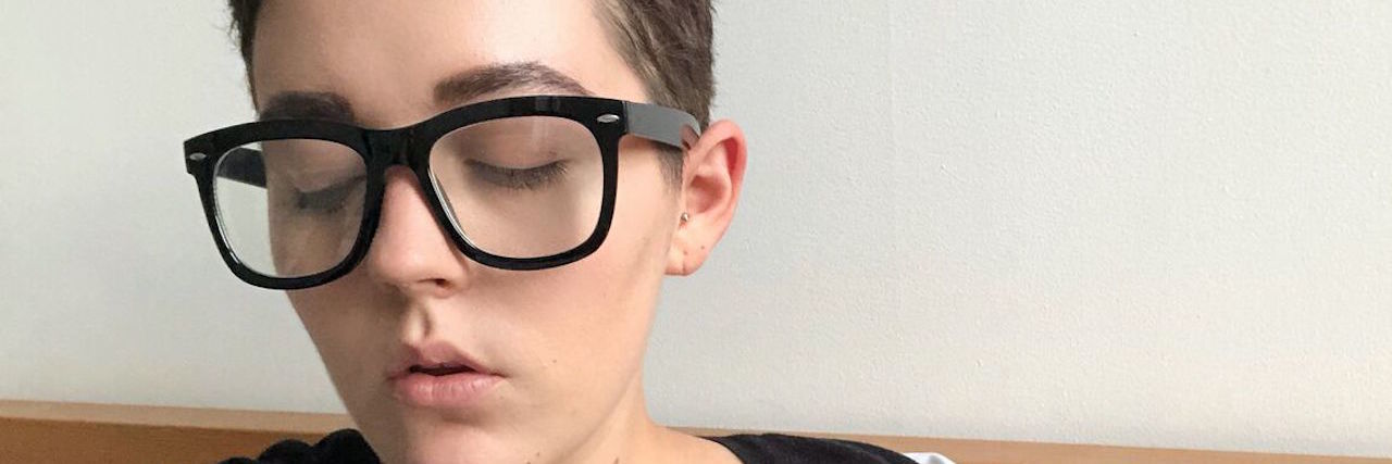What Chopping My Hair Off Meant About My Depression woman with short hair and glasses looks away from the camera