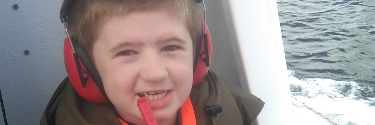 My Brother With Autism Is a Person, Too Dian riding in a boat, wearing his noise-cancelling headphones.