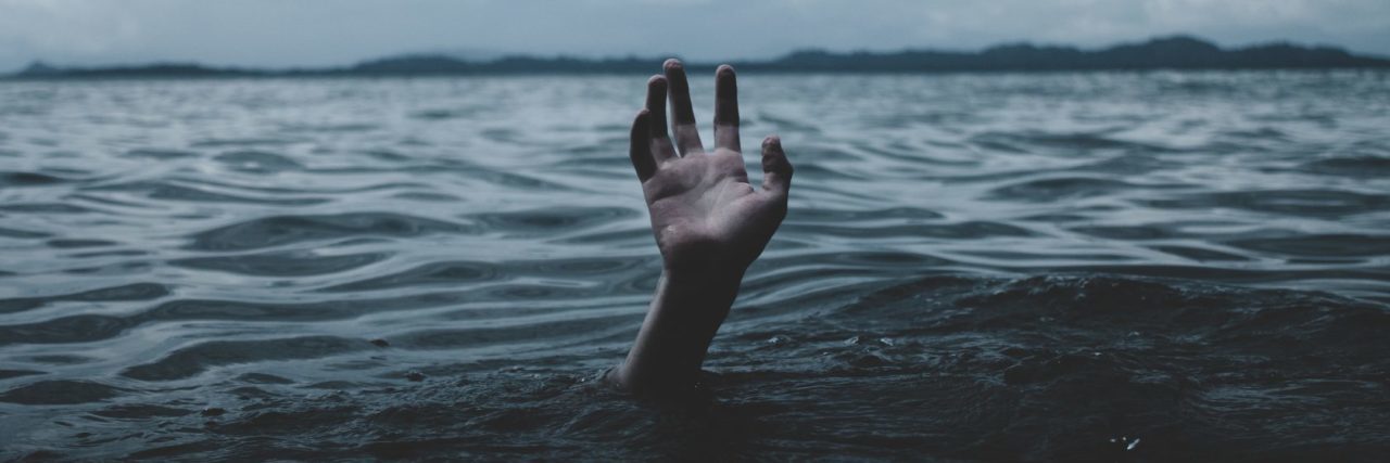 Why Some People Struggle to Talk About Mental Illness person in stormy ocean with only hand visible drowning