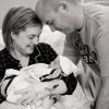 Black and white image of couple holding a baby with Down syndrome