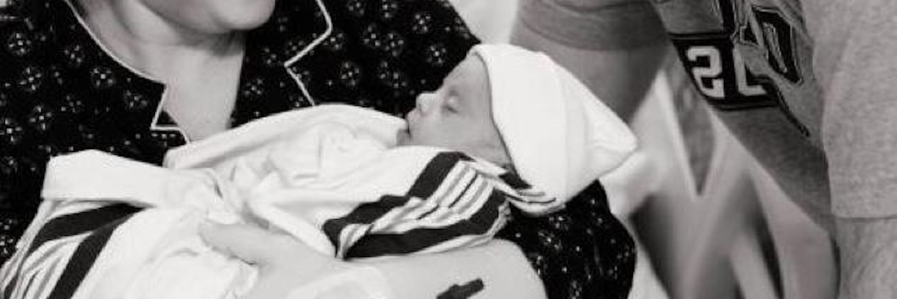 Expecting My Second Child With Down Syndrome Black and white image of couple holding a baby with Down syndrome