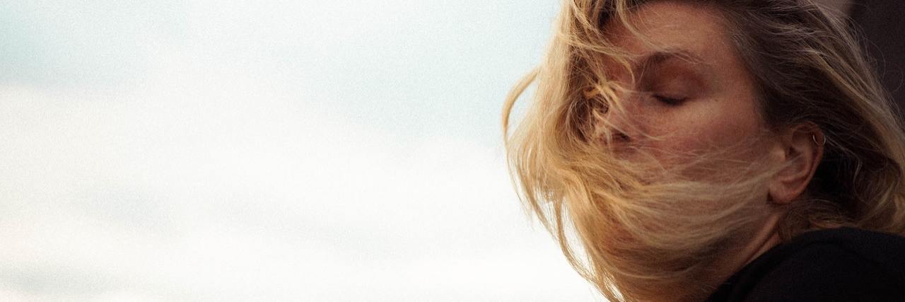 How Endometriosis Makes You Worried About Infertility A woman outside, with her hair blown in her face