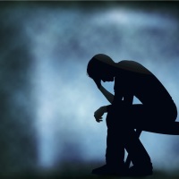 the silhouette of a man sitting on a chair with his down