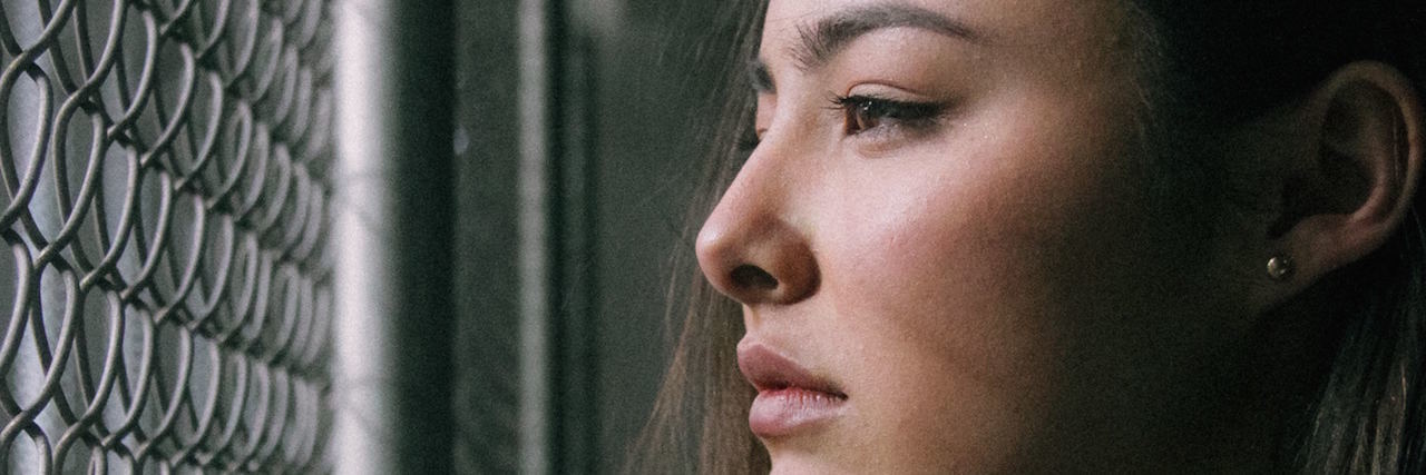When You Can't Tell Where You End and Your Mental Illness Begins woman face looking through gate