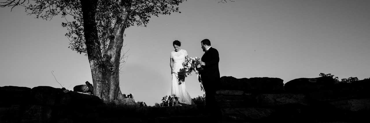 black and white photo married couple wedding beside tree