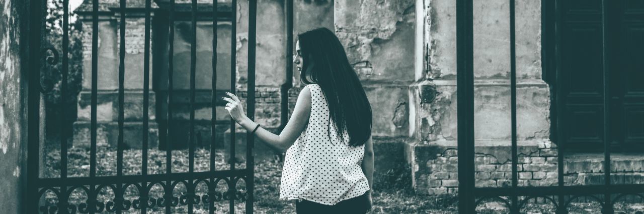 5 Types of Self-Care for Your Mental Health woman opening a gate. photo in black and white