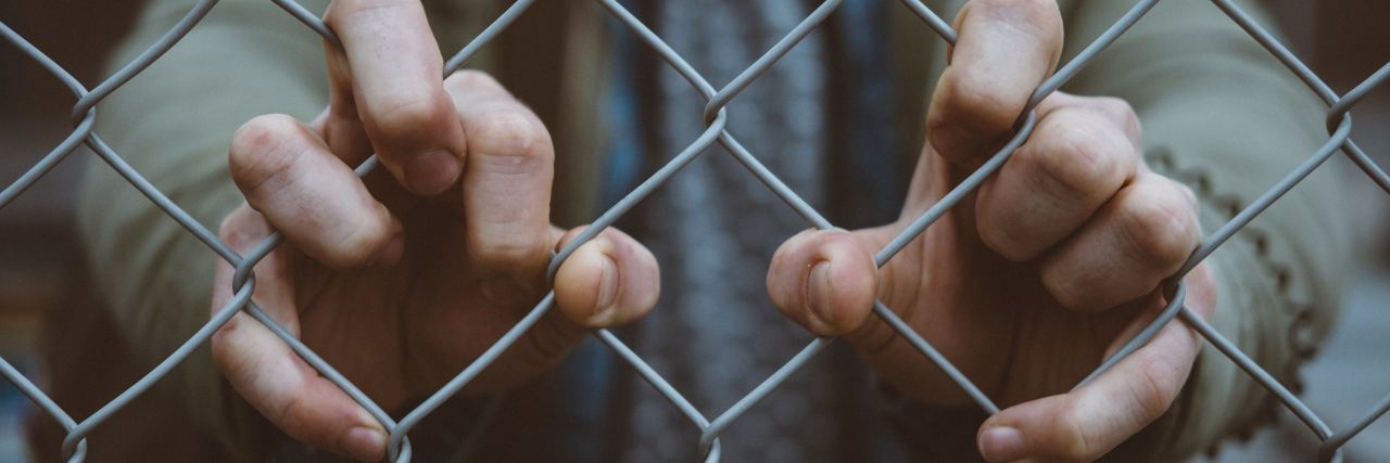 What I Want You to Know About National Survivors of Suicide Day hands holding mesh fence