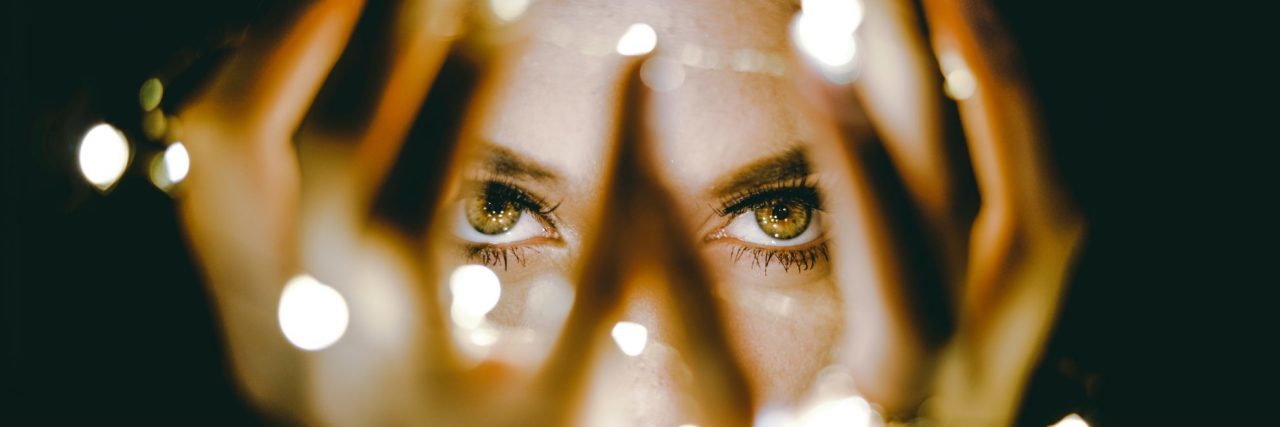Why I Speak Up About My Sexual Assault and Abuse Close up of woman holding fairy lights in hands looking directly into camera defiant