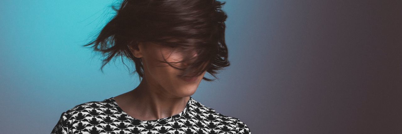 When I Was Finally Diagnosed With Borderline Personality Disorder woman with short dark hair swinging her hair in front of her face