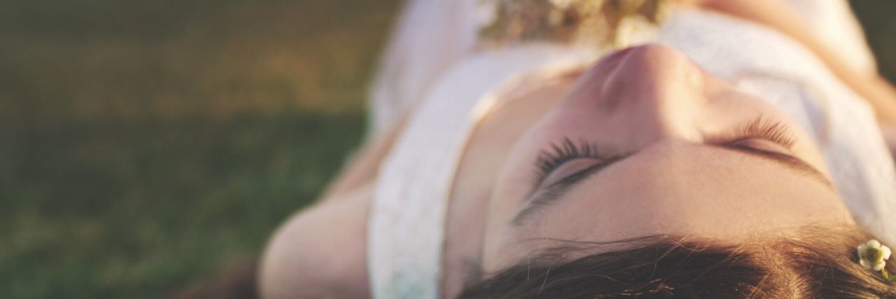 How Wise Mind and Dialectical Behavior Therapy Helps Me young woman laying on ground with flowers in her hair