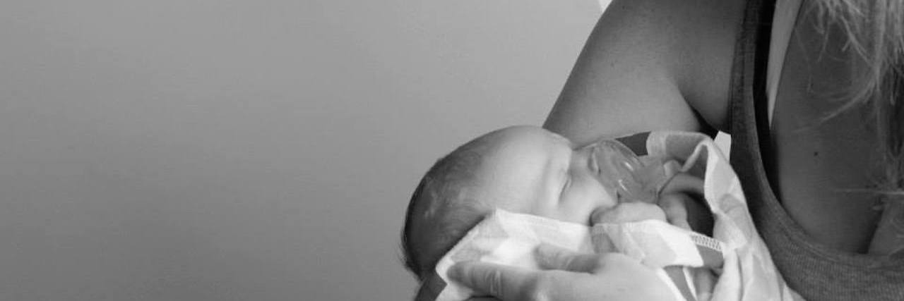 black and white photo of woman holding her newborn baby