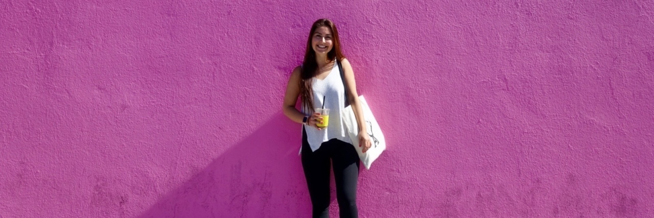 The writer standing in front of a purple wall.