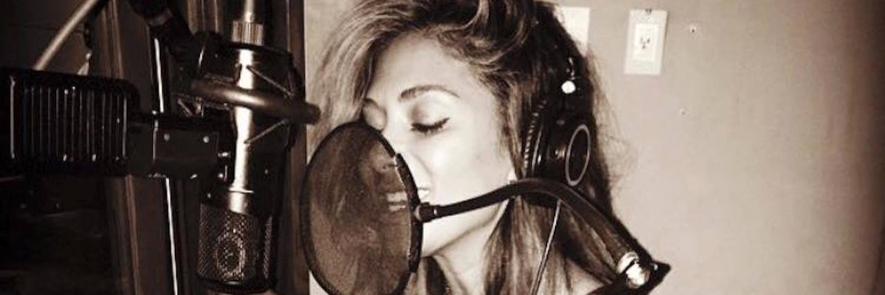 Nicole Scherzinger's Music Helped Inspire Me Through My Illness A photo of Nicole singing into a mic, recording a song.