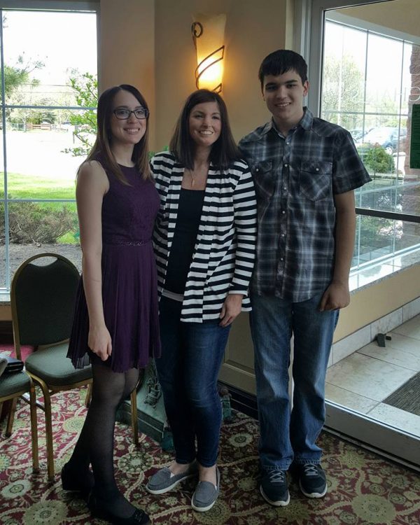 three people standing together and smiling