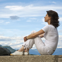woman sitting on a wall overlooking the scenery