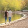 Couple walking together on a lake beach and holding hands.