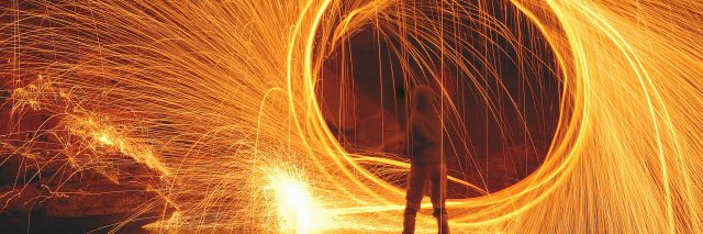 Woman standing in front of a ring of fire.