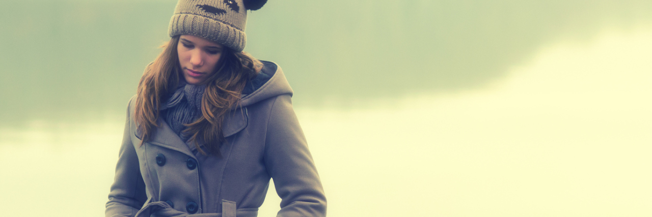 I Don't Know Where I End and My Avoidant Personality Disorder Begins sad young woman standing outside alone next to lake in winter