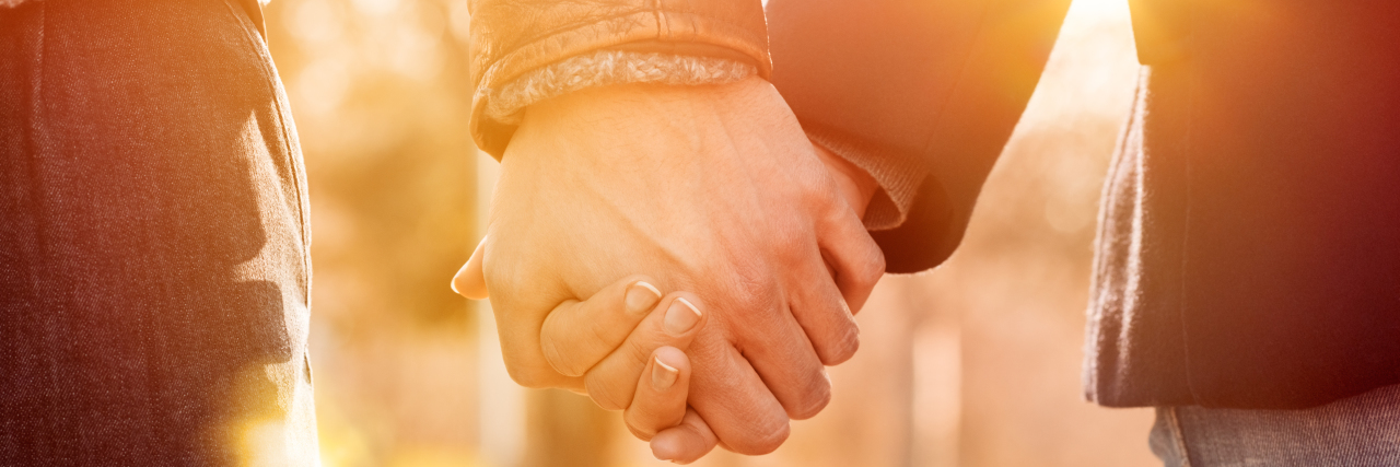 A New Paradigm for Making Love With Prostate Cancer Closeup of loving couple holding hands while walking at sunset