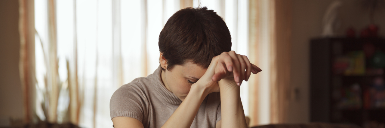 When My Childhood Coping Mechanism Became Harmful as an Adult Pretty young woman sitting at a table and sad