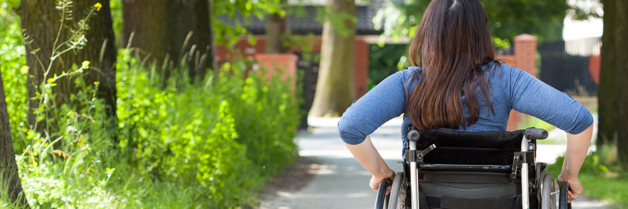Young woman in wheelchair rolling in the park.