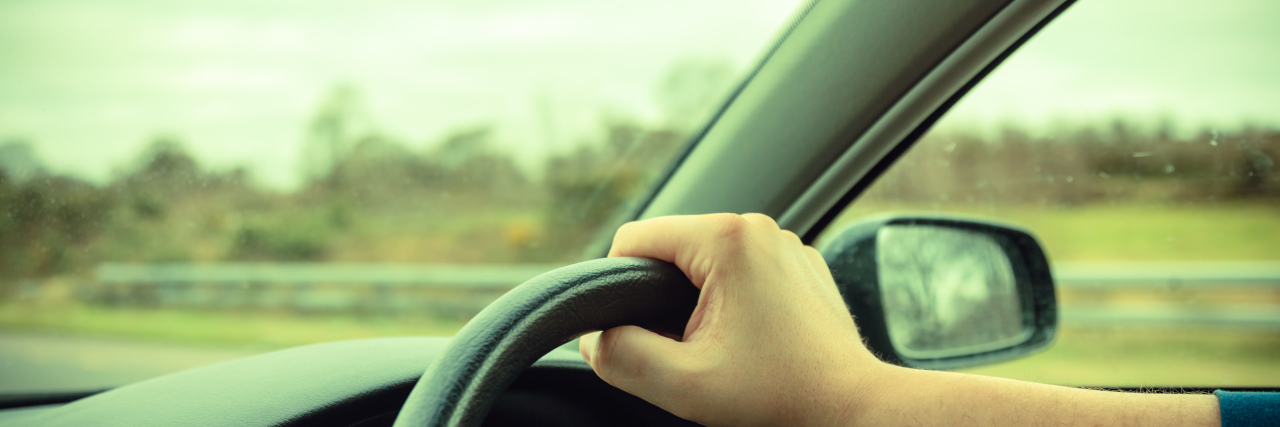 Sensory Overload and Driving as a Person With Autism Man with hands on steering wheel driving.