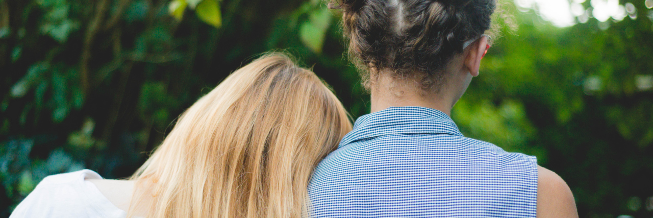 How to Support a Loved One With Dissociative Identity Disorder two girls outside support with one head on other's shoulder