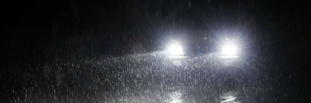 Getting Hit by a Car as a Wheelchair User Bright headlights on a rainy night.