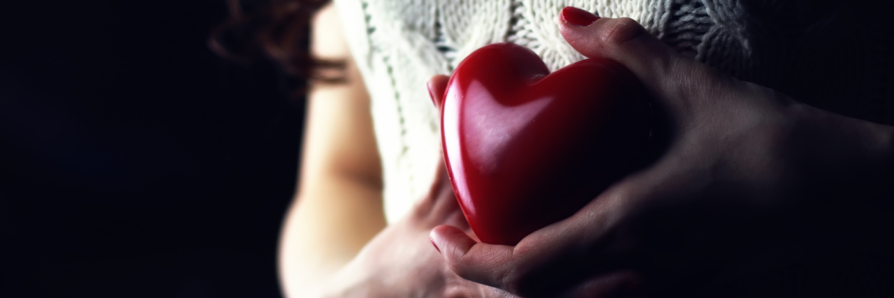 How to Explain Anxiety When Someone Asks woman with heart in hands resting on chest