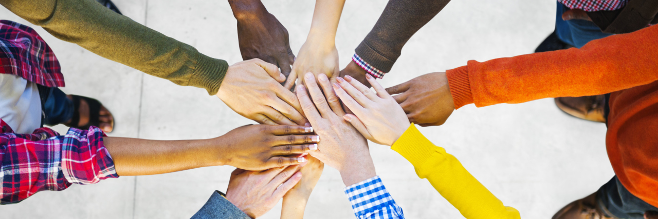 Group of Diverse Multiethnic People putting hands together to indicate Teamwork