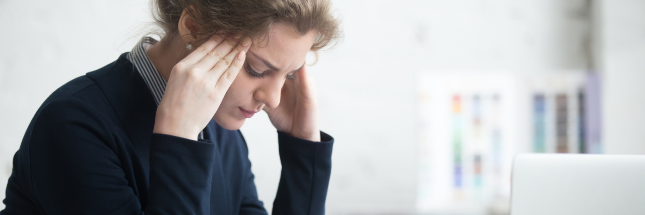 Depression and Anxiety: Opposite Illnesses Fighting Together young woman in front of laptop stressed depressed hands at temples