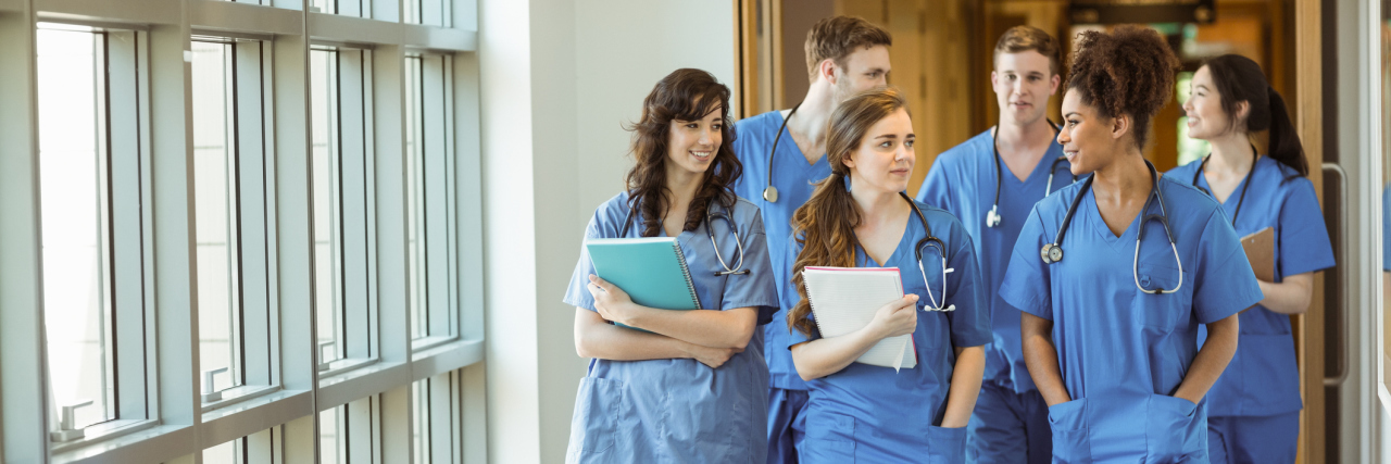 2 Types of Doctors You Need to Know About If You Have a Rare Condition People in scrubs walking down a hallway.
