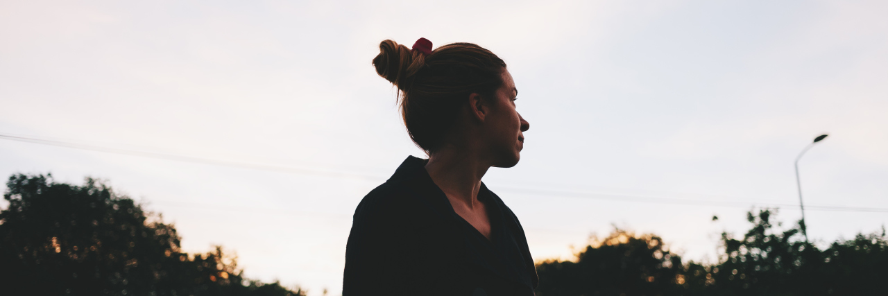 What One Year Out of Eating Disorder Treatment Has Been Like The silhouette of a young woman looking at sunset in the distance