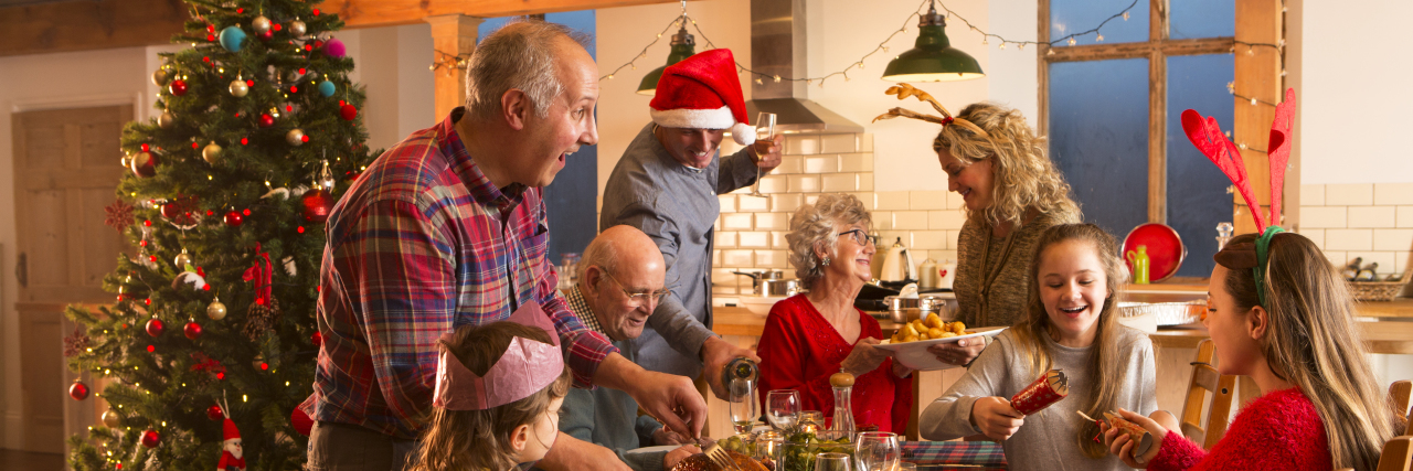 3 Ways I Survive Holiday Dinners in Eating Disorder Recovery A large family are all helping serve Christmas dinner.