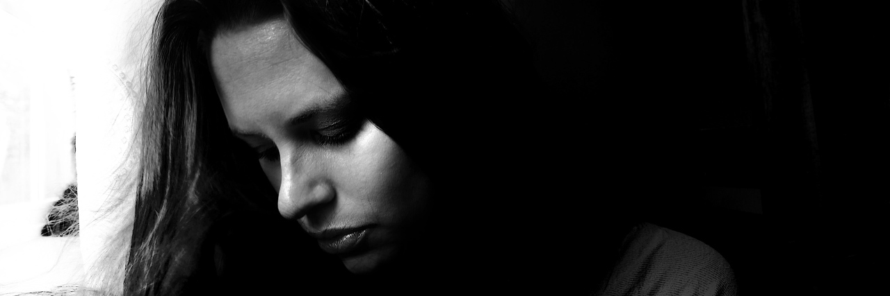black and white image of girl looking eyes down, thoughtful and sad