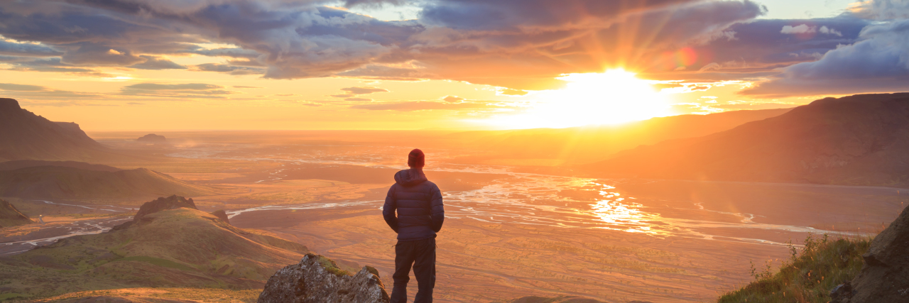 Stuttering, Asperger's and Self-Acceptance Man standing on a ledge of a mountain, enjoying the sunset over a river valley in Thorsmork, Iceland.